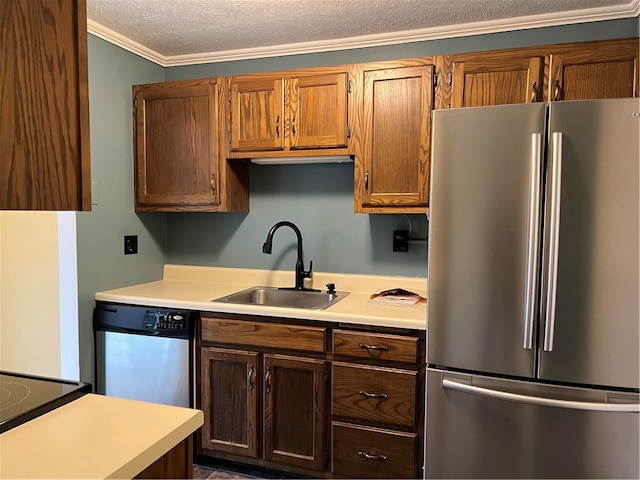 kitchen with a textured ceiling, stainless steel appliances, ornamental molding, and sink