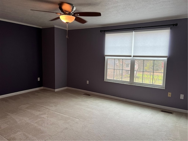 unfurnished room featuring ceiling fan, light colored carpet, a textured ceiling, and ornamental molding