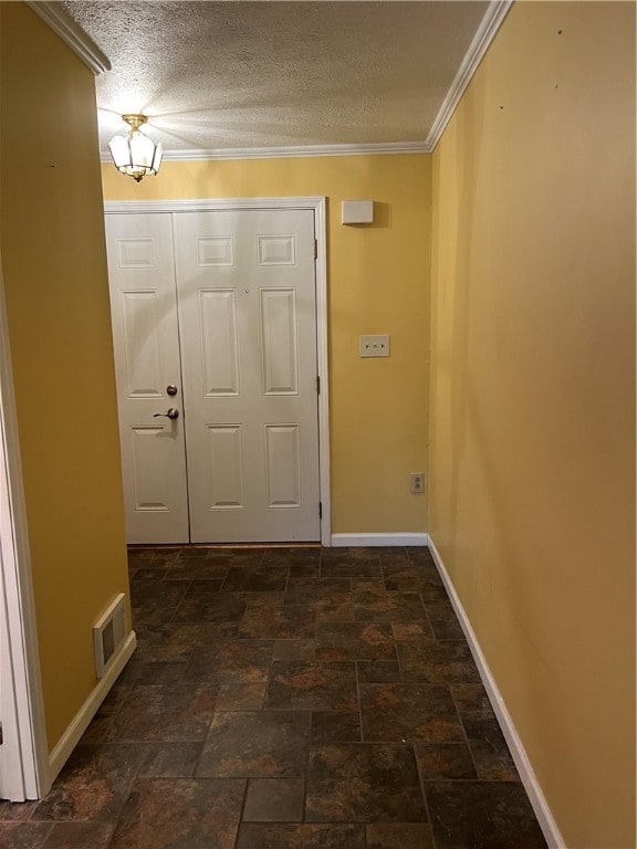 entryway featuring a textured ceiling and crown molding