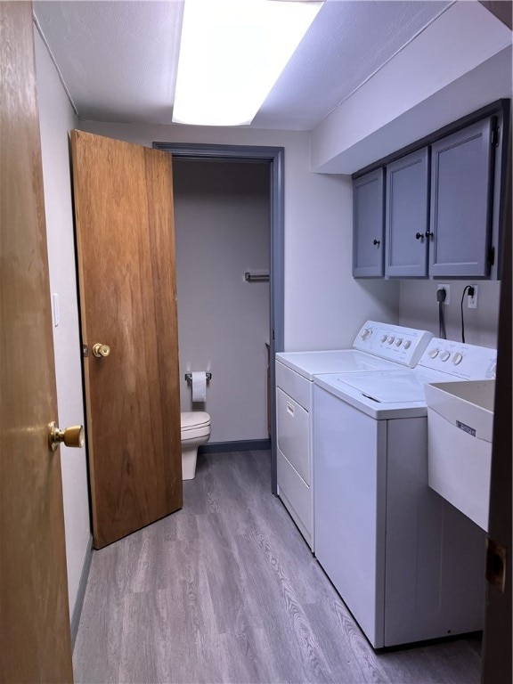 washroom featuring washer and clothes dryer and light hardwood / wood-style floors