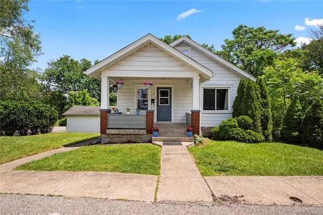 bungalow-style house with covered porch and a front lawn