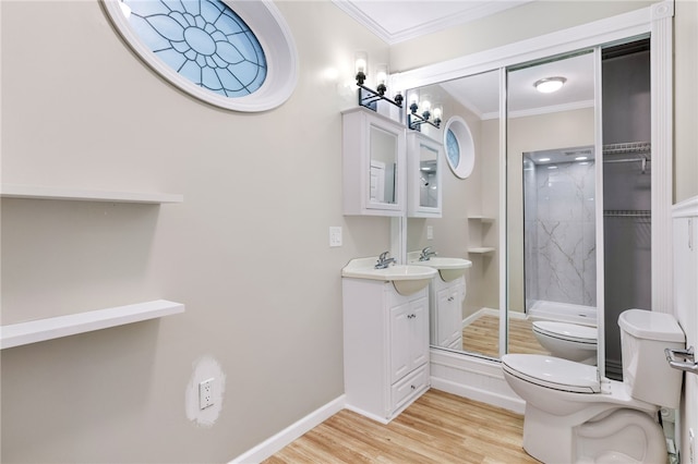 bathroom featuring toilet, hardwood / wood-style flooring, a shower with shower door, ornamental molding, and vanity