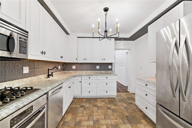 kitchen featuring backsplash, appliances with stainless steel finishes, sink, and white cabinetry