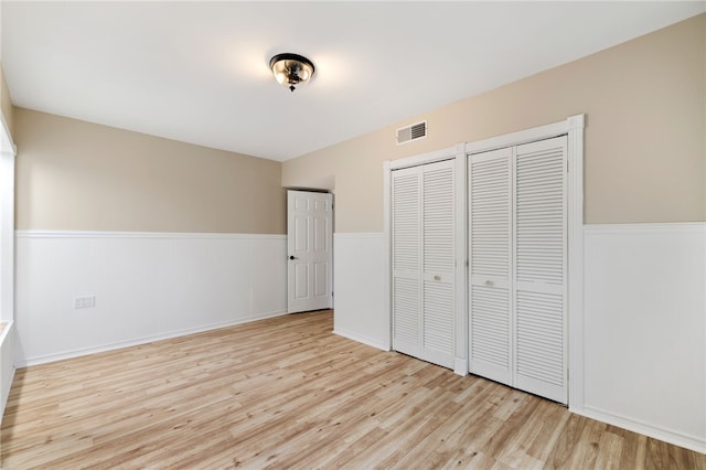 unfurnished bedroom featuring two closets and light wood-type flooring