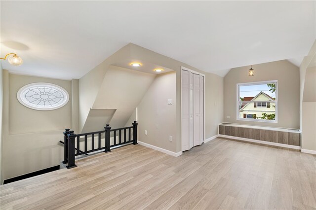 bonus room with light hardwood / wood-style flooring and vaulted ceiling