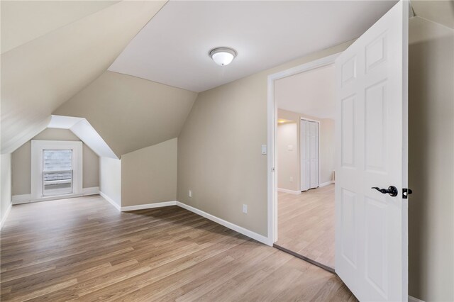 bonus room with light hardwood / wood-style flooring and vaulted ceiling