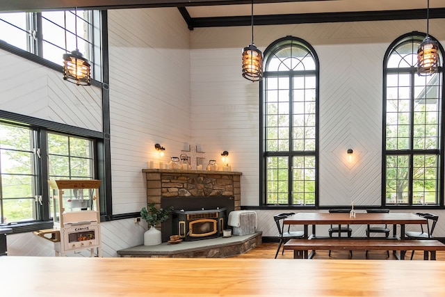 living room featuring hardwood / wood-style floors, a stone fireplace, and a wood stove