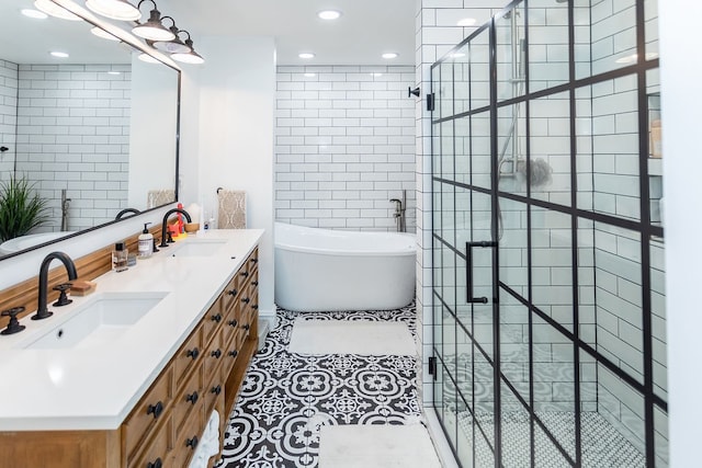 bathroom featuring vanity with extensive cabinet space, dual sinks, tile floors, and independent shower and bath