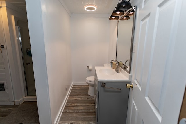 bathroom featuring toilet, an enclosed shower, vanity, and hardwood / wood-style flooring