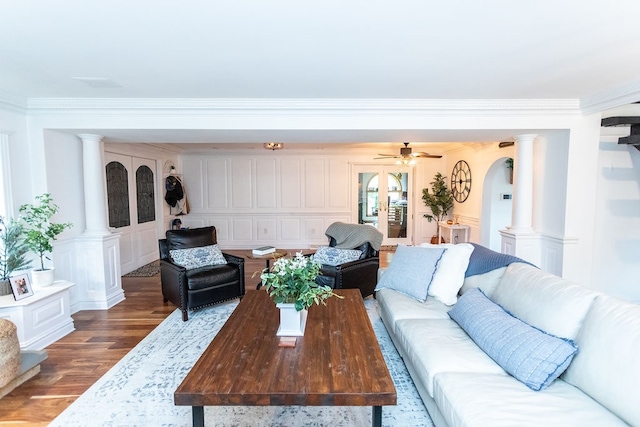 living room featuring crown molding, decorative columns, wood-type flooring, and ceiling fan