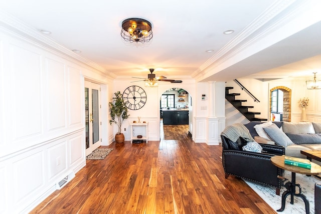 living room featuring dark hardwood / wood-style floors, ceiling fan, and ornamental molding