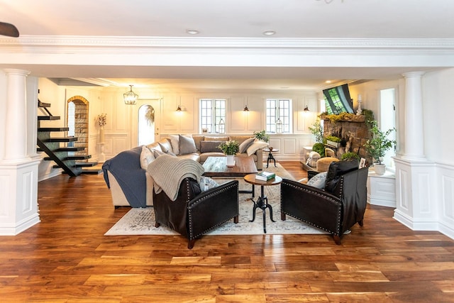 living room featuring hardwood / wood-style floors, ornamental molding, and decorative columns