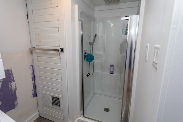 bathroom featuring a shower with door