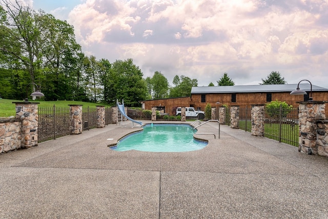 view of pool with a patio and a water slide