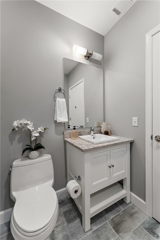 bathroom with tile floors, toilet, and vanity