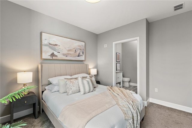 bedroom with dark colored carpet and ensuite bathroom