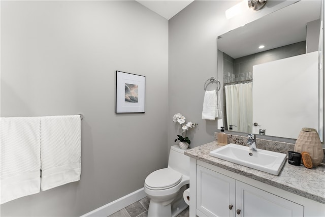 bathroom featuring tile flooring, vanity, and toilet