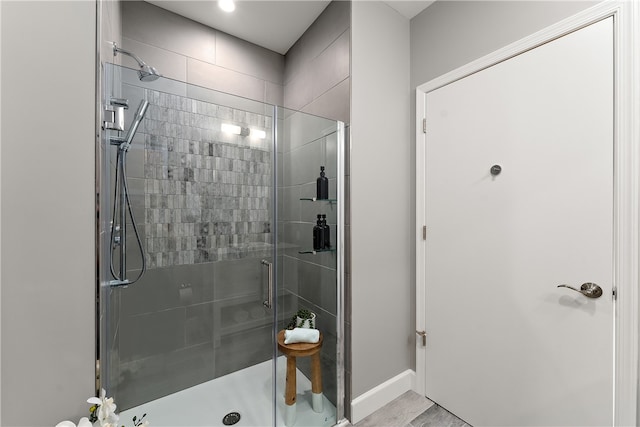 bathroom with a shower with shower door and hardwood / wood-style flooring