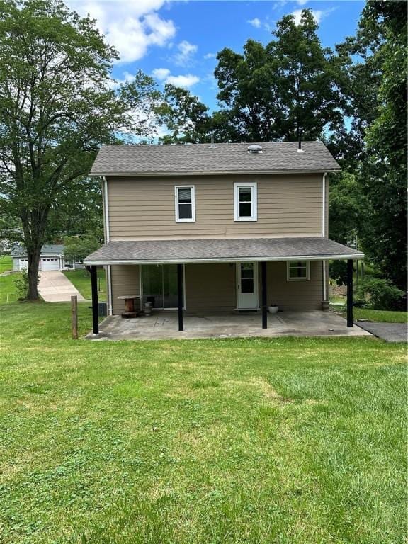 rear view of house with a yard and a patio