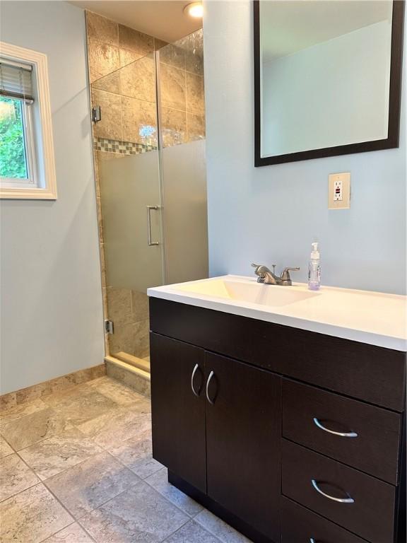 bathroom featuring vanity and an enclosed shower