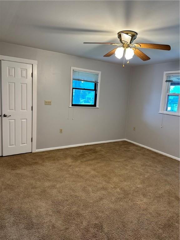 empty room featuring carpet flooring and ceiling fan