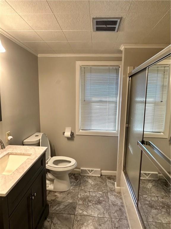 full bathroom featuring shower / bath combination with glass door, crown molding, vanity, and toilet