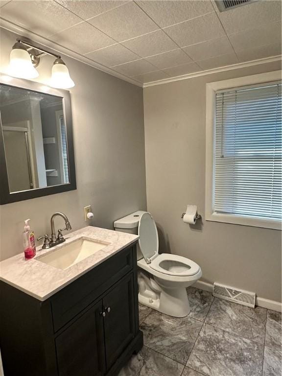 bathroom with vanity, toilet, and ornamental molding