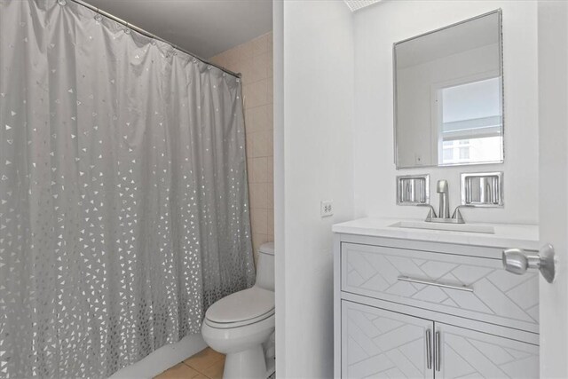 bathroom featuring vanity, toilet, and tile floors