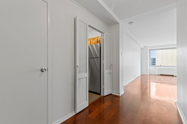 corridor with hardwood / wood-style flooring and lofted ceiling