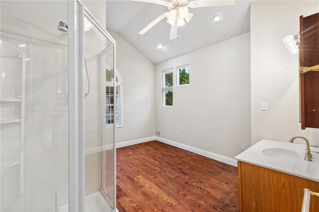 bathroom with ceiling fan, hardwood / wood-style flooring, a shower with door, vanity, and lofted ceiling