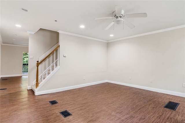 spare room with crown molding, visible vents, wood finished floors, baseboards, and stairs