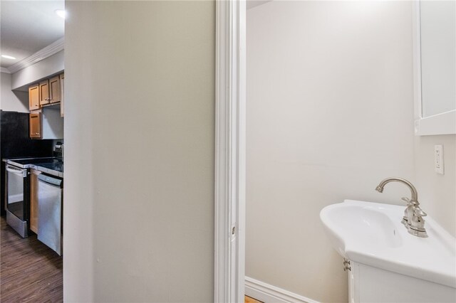 bathroom with crown molding and hardwood / wood-style floors