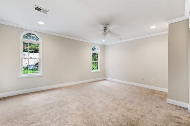 spare room featuring carpet, ceiling fan, and crown molding