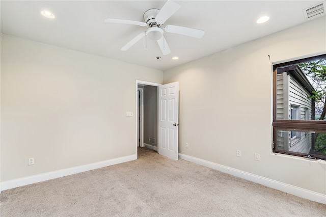 carpeted spare room with ceiling fan