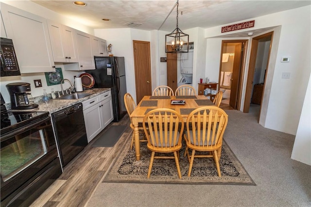 dining area featuring light hardwood / wood-style floors, a chandelier, and sink