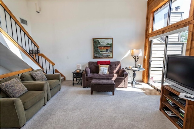 carpeted living room featuring a high ceiling