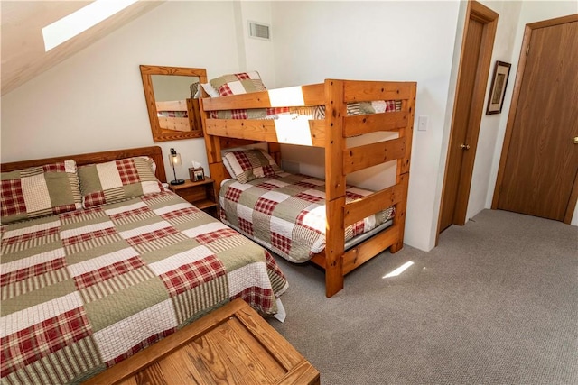 carpeted bedroom with vaulted ceiling with skylight