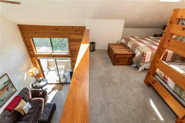 bedroom with a skylight, wooden walls, and light colored carpet