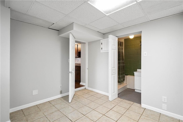 tiled empty room with a paneled ceiling