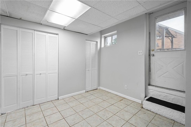 basement with light tile patterned flooring and a drop ceiling