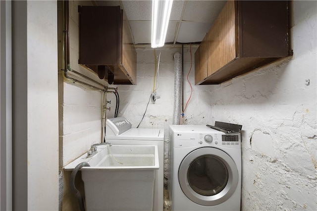 washroom featuring cabinets, washing machine and dryer, and sink