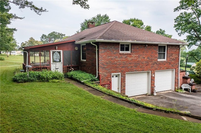 view of home's exterior featuring a yard, a garage, and a sunroom