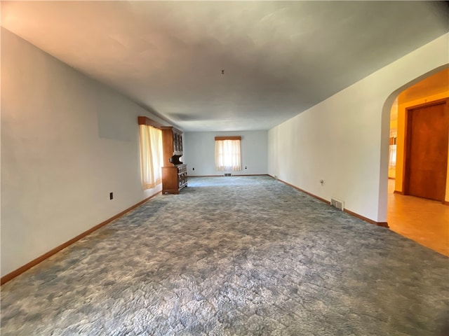 unfurnished living room featuring dark carpet