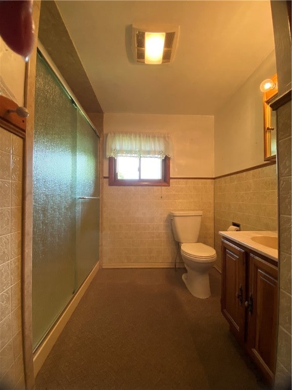 bathroom featuring vanity, an enclosed shower, tile walls, and toilet