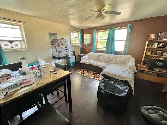 living room with ceiling fan and dark wood-type flooring