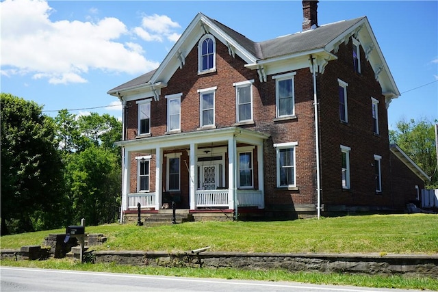 view of front facade featuring covered porch and a front yard