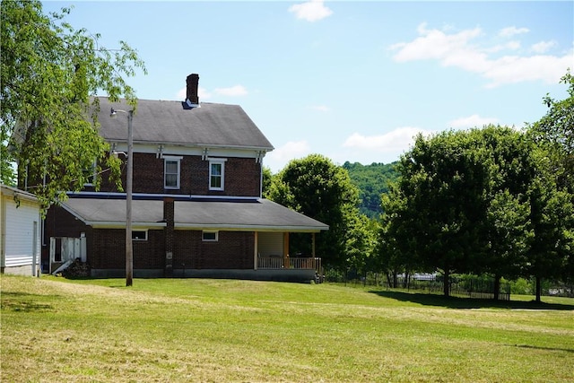 back of property with a lawn and a porch