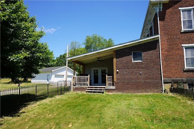 rear view of property with french doors, a yard, and ceiling fan