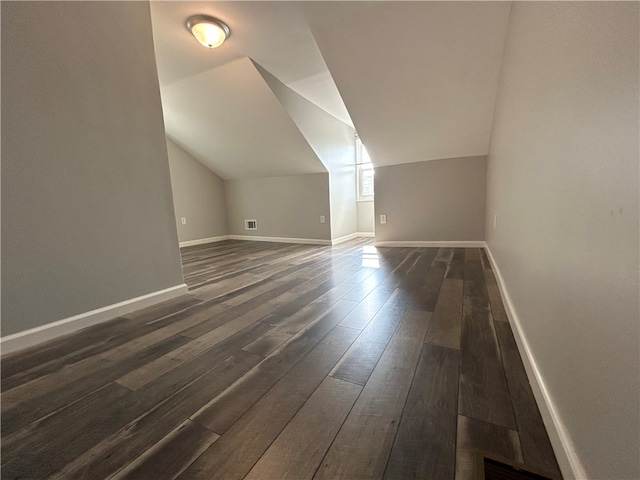 bonus room with lofted ceiling and dark hardwood / wood-style floors