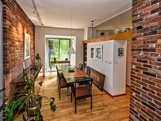 dining area with light hardwood / wood-style flooring and rail lighting